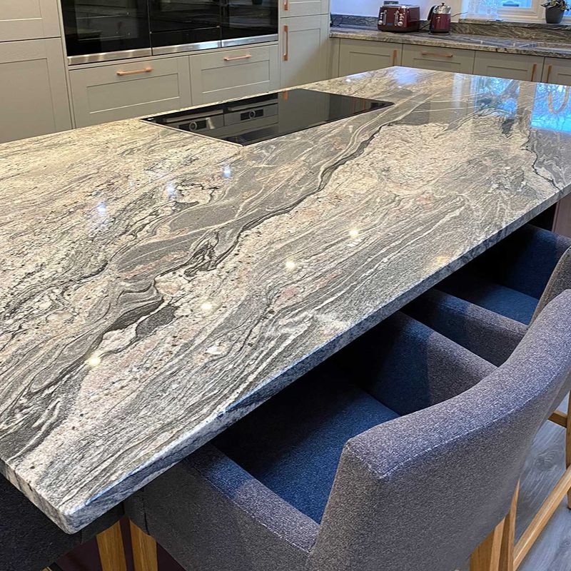 kitchen with a stone work top and chairs
