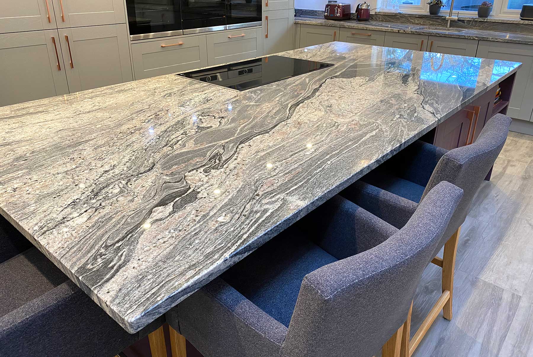 kitchen with a stone work top and chairs