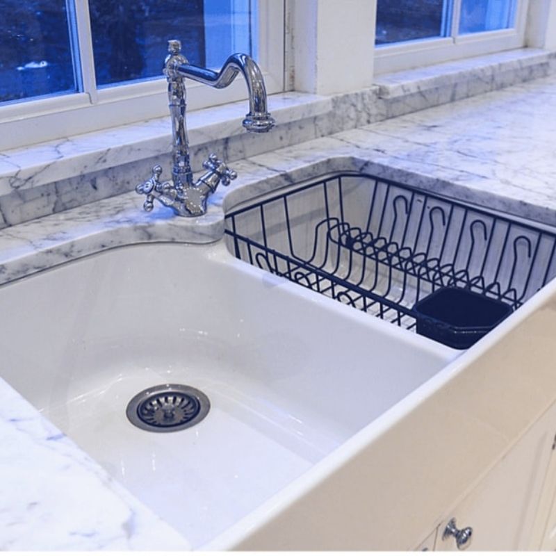 a kitchen with a sink and stone work top